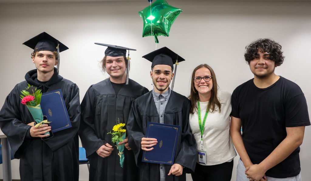 Journey students pose in the graduation cap and gowns.