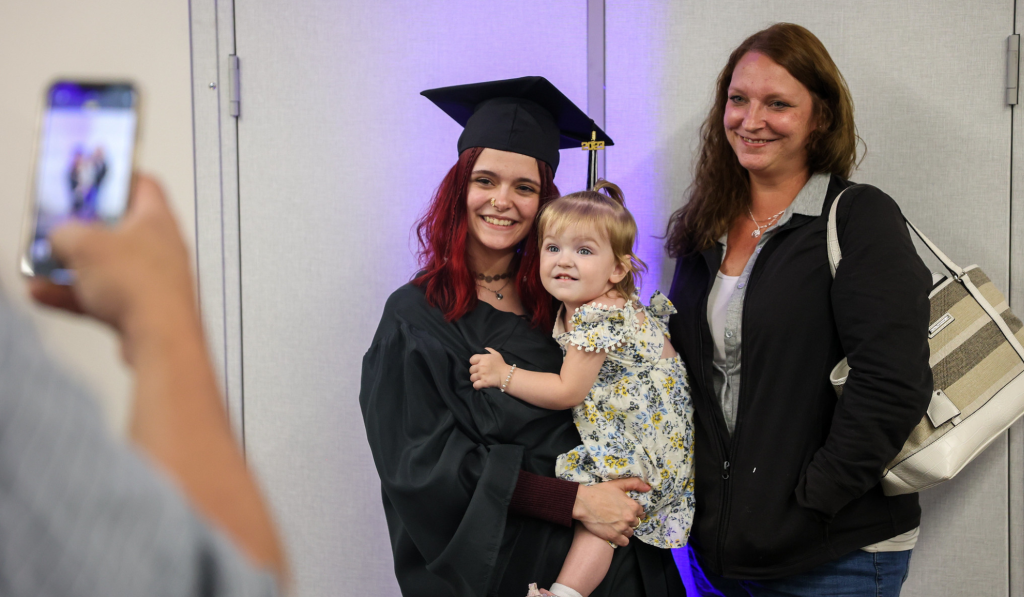 Journey student poses for a photo with her small daughter.