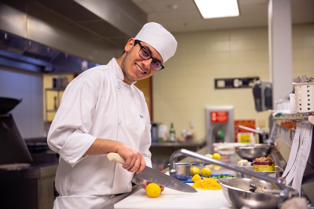 Culinary student smiling and cooking
