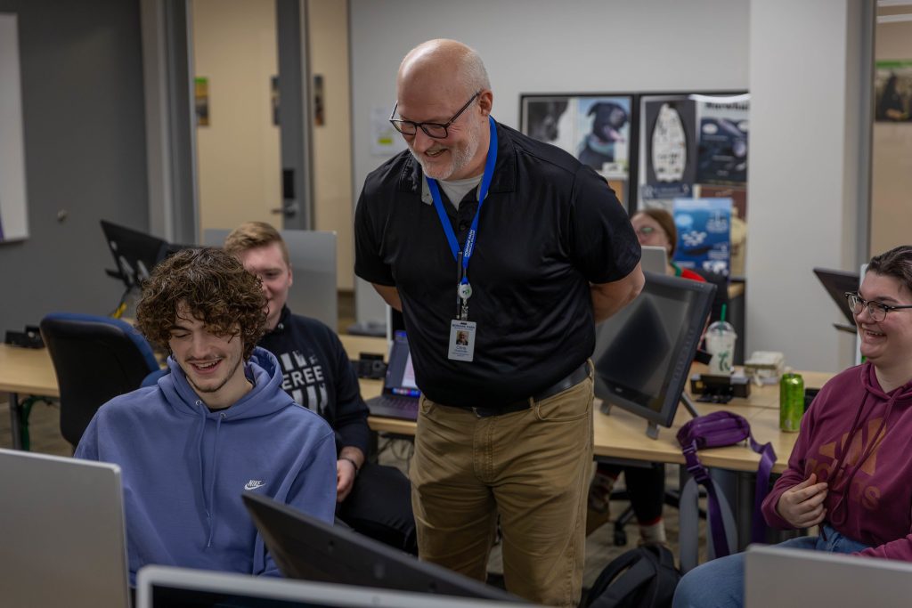 Business Instructor Chris Dudzinski interacting with students in a classroom.