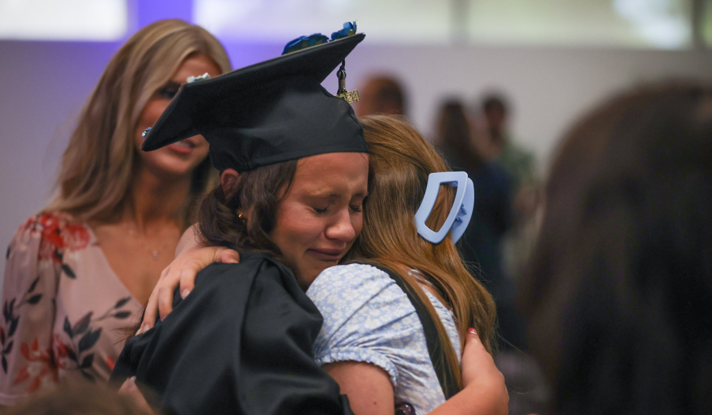 An emotional journey student hugs her family at graduation.