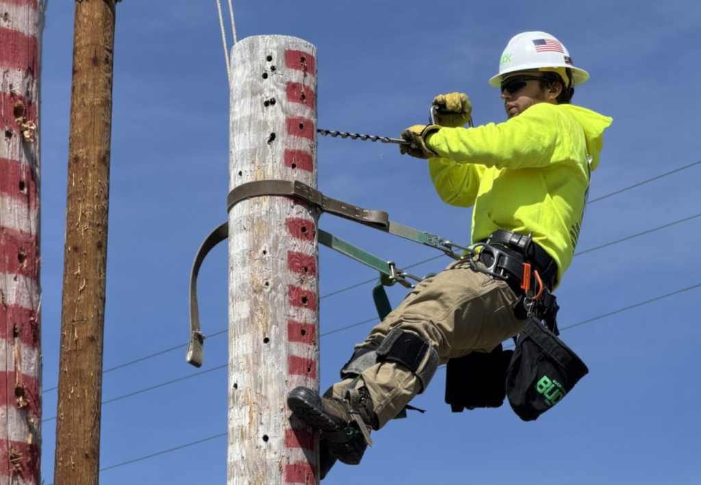 A student is climbing an electrical pole in the EPD Rodeo Competition.