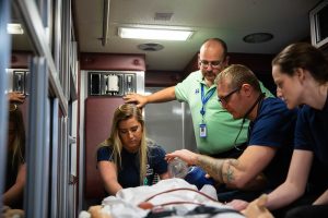 Paramedic Students working on a simulation in the back of an ambulance.