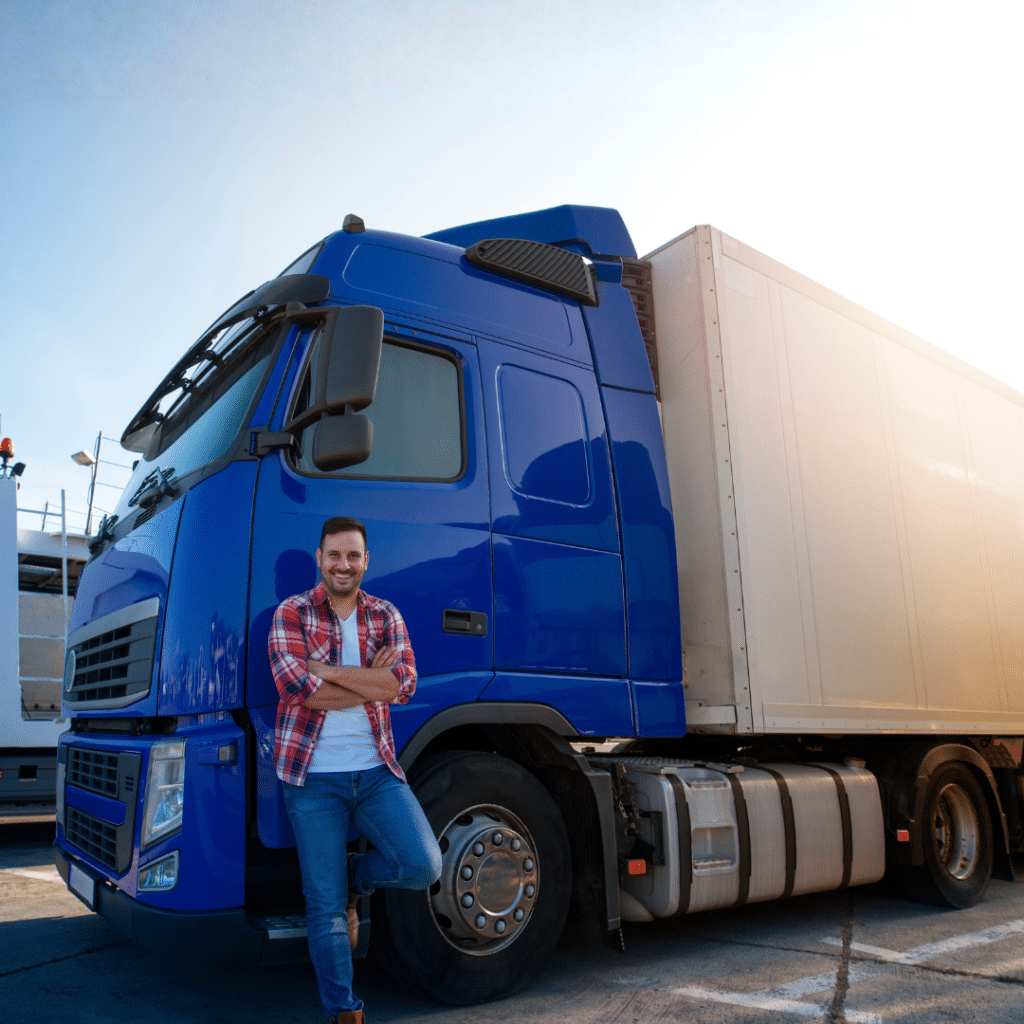 Truck driver with crossed arms and smile on his face standing by his truck on a break ready for a ride.
