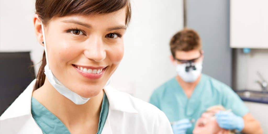 Clinical Dental Assistant in her dental work outfit smiling into the camera.