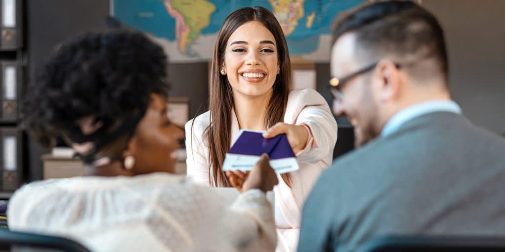 Customers and their travel agent in chatting about an upcoming trip.